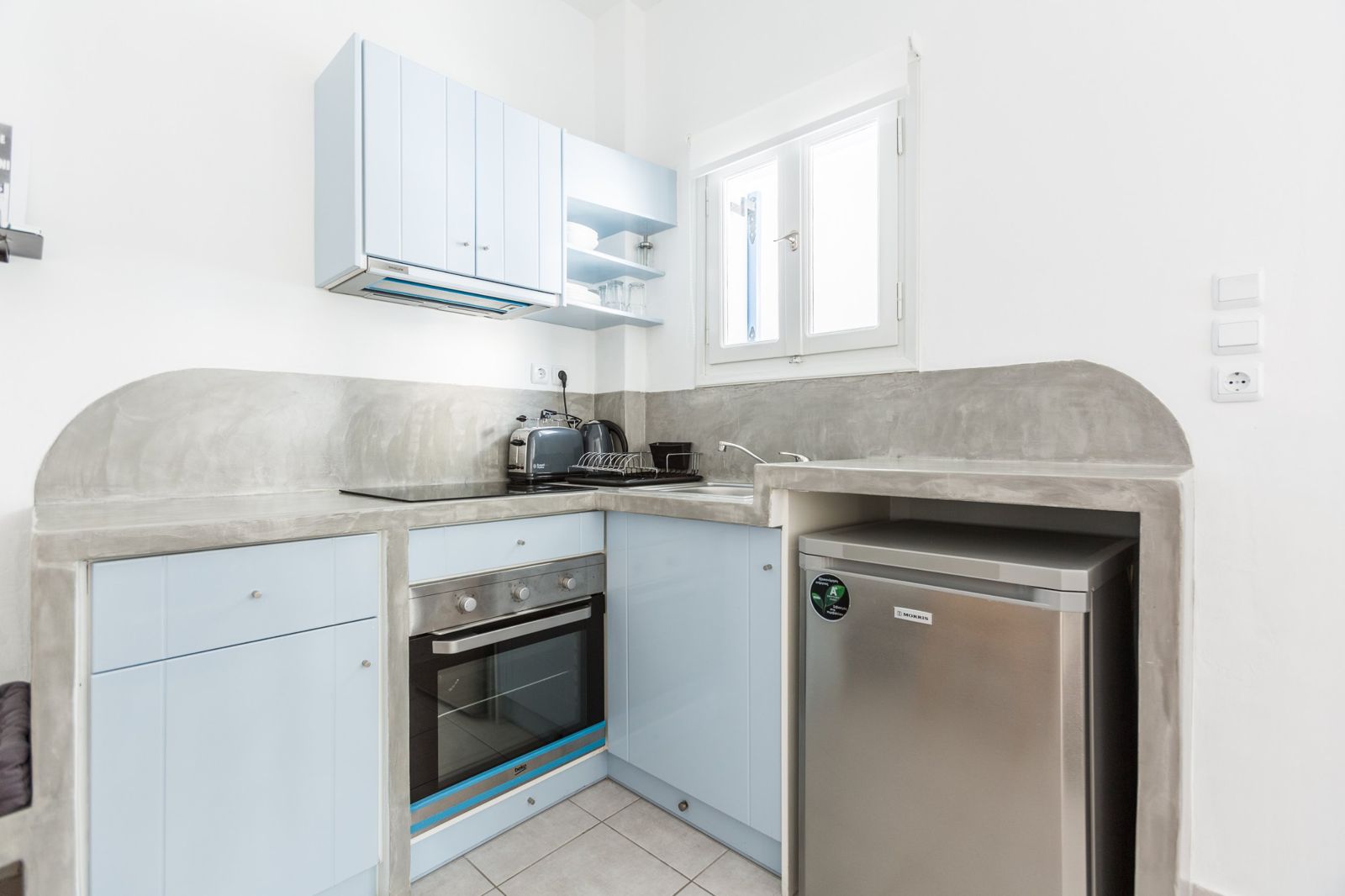 Kitchenette of the Traditional Apartment with pale-blue cabinets, oven and fridge